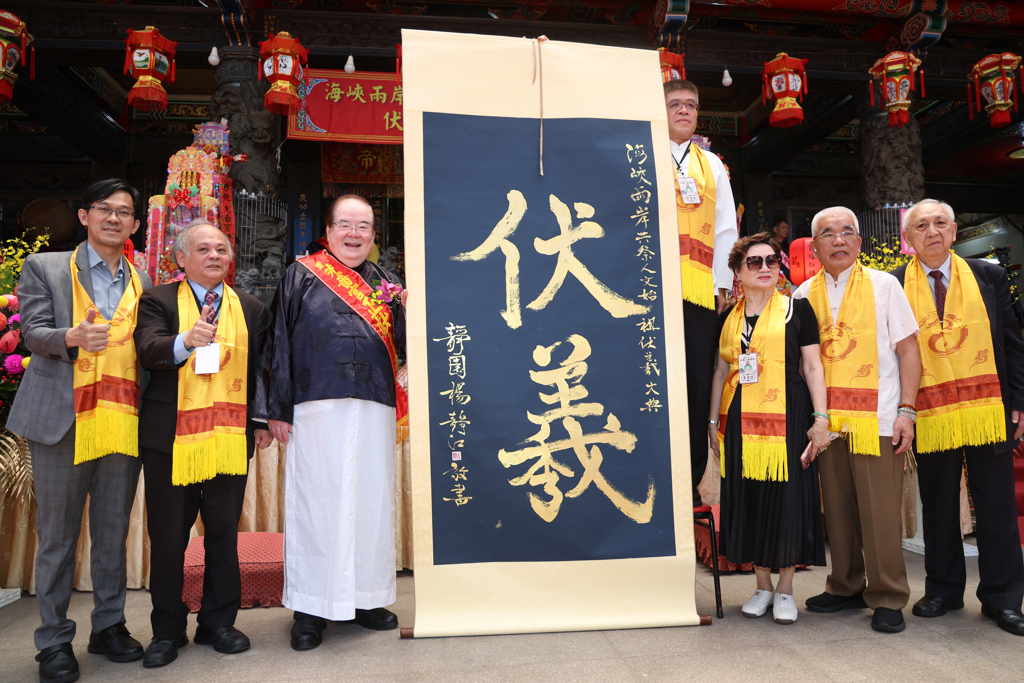 新北市三重區先嗇宮21日舉辦「2026海峽兩岸共祭中華人文始祖伏羲三獻大典」,國民黨副主席、先嗇宮董事長李乾龍(左三)擔任主祭官,與貴賓共同展示「伏羲」書法卷軸,象徵弘揚伏羲文化與中華人文精神。(鄧博仁攝)